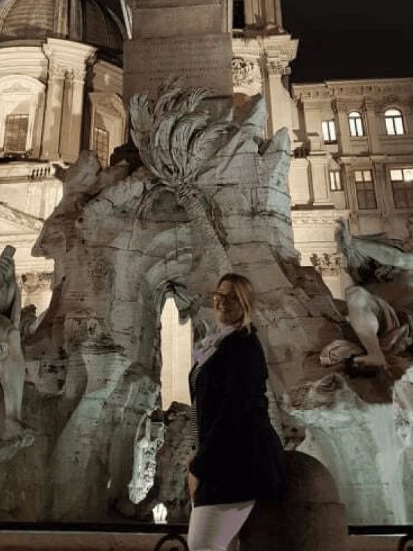 Young white woman wearing glasses and posing in front of a monument